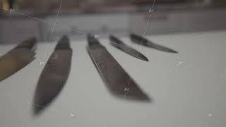 Close up of knives set lying on a white table surface in the kitchen. Action. New sharp steel knives