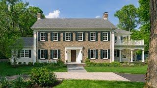 Traditional New England Colonial house with woodlands backdrop