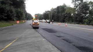 Asphalt roller compacting asphalt on a utility trench repair