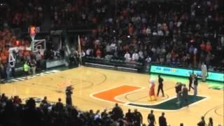 Sebastian (Canes mascot) and Dwyane Wade shoot from the middle court line.