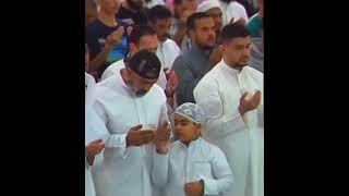 A spontaneous scene of a child kissing his father's hand during prayer. Masha Allah