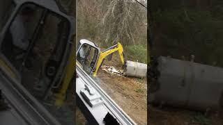 Using excavator to move old oil tanks