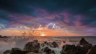 Dramatic sunset on a tropical beach with rocky shoreline in 4K