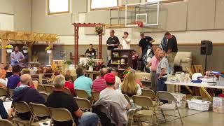 Elmer Yoder auctioneer selling quilt.