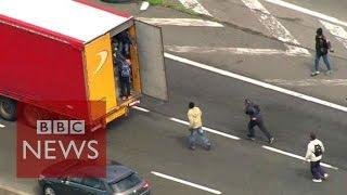 Moment Calais migrants jumped onboard lorries - BBC News