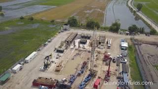 Fly over the land rig located in the middle of flooded rice field (Land rig aerial view)