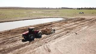 TOOMEY 4000B Scraper using teeth edges to dig out a stock dam to increase storage capacity.