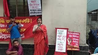 Taslima Akhter in front of minimum wage board