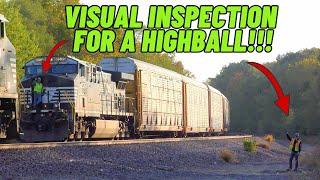 A crew does a visual inspection for a Highball after boarding a train tied down in the hole....