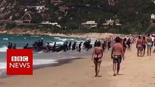 A boat full of migrants lands at a popular tourist beach in southern Spain - BBC News