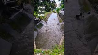 Kids enjoy playing and swimming in irrigation canal.