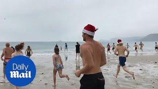 Moment festive swimmers brave freezing waters on Christmas Day