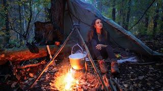 The girl is building a shelter in the forest.  Solo Bushcraft