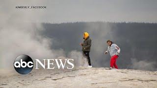 Men stick heads in Old Faithful geyser