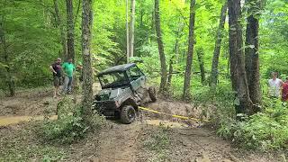 Can Am Defender rolls over in a deep rut.