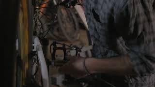 a millennial man bike mechanic adjusts the rear derailleur on a mountain bike in his shop