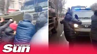 Ukrainian protesters facedown Russian military vehicles in city of Melitopol