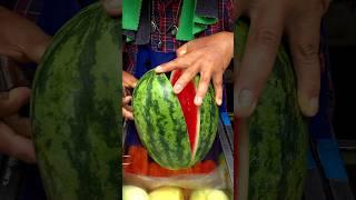 A neat watermelon cut by an old man on a street cart