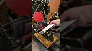 Printing some red  greeting cards with a tabletop printing press