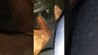 Girl flooring pedal hard and fast driving with one feet barefoot and one boots in highway