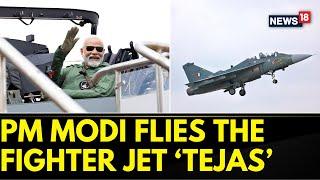 PM Modi News | PM Modi Flies In Light Combat Tejas Fighter Jet In Bengaluru | English News | News18