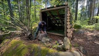 Man builds a warm shelter for survival in the forest, solo bushcraft camping in the wild