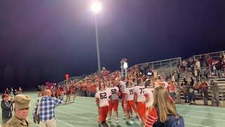 Natrona County players carry the Oil Bowl trophy over to the NC student section after defeating