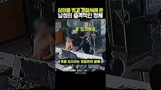 A man takes off his shirt and goes to the police station