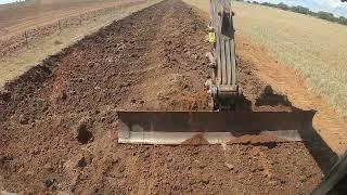 12ft grader blade attachment working on Volvo excavator building drainage ditch