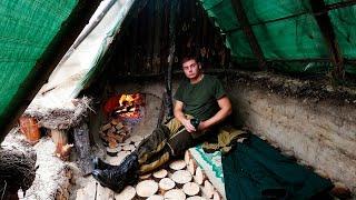 Building a warm survival shelter in the ground, fireplace made of stone and clay, cooking