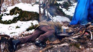 Winter Bushcraft Camping. Primitive shelter building in mountain forest. Campfire cooking.