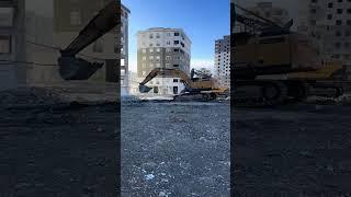 Two excavators pulled thick steel cables to pull down the unfinished illegal building.