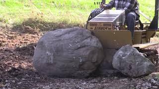 Struck - MAGNATRAC MH4900 small bulldozer pushing huge rock.