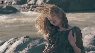 sensual girl poses at riverbank on windy