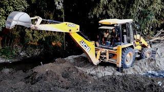 JCB Backhoe Loaer Working Near The River To Build The Village Road