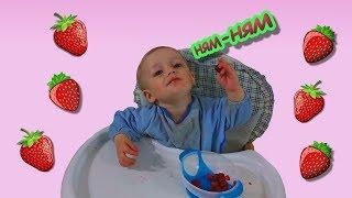 Малыш забавно ест клубнику/Baby funny eats strawberries.