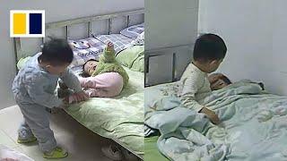 Boy puts little sister to sleep while mother is at work