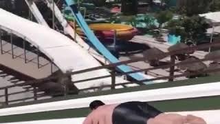 A fat guy going down on the water slide and this happen