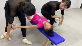 Passive middle split stretching with two coaches