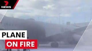 Plane erupts in flames America | 7NEWS