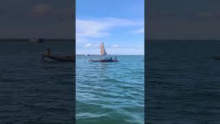 Dugout wood canoe with a plastic tarp for a sail, towing family in another canoe behind. png vibes