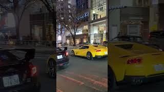 A Bright Yellow Colored Car passing through Shibuya.