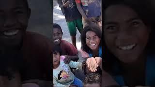 Curious children in Central Madagascar see a stranger on a motorcycle.