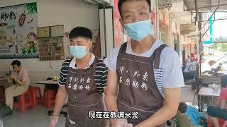 润发认真地为刚来学做肠粉的学员讲解，如何做肠粉？如何调米浆？