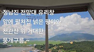 마치 한폭의 풍경화 사진처럼 정남진 전망대 카페 유리창 앞에 펼쳐진 넑은 평야와 천관산 위에 떠 있는 거대한 뭉개구름.~