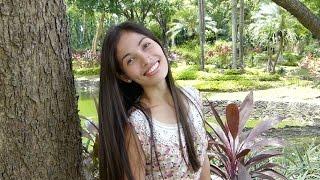 YOUNG MODEL FLIRTS WITH CAMERA. TROPICAL GARDEN IN CEBU. PHILIPPINES. TRAVEL.