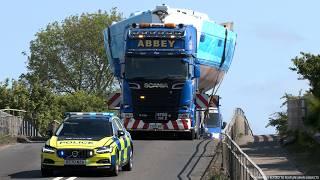 Police move traffic aside for an oversize Yacht travelling by road as a wide load
