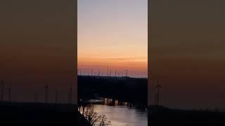 Beautiful sunset with wind mills and a river passing by. #sunset #landscape #nature #shorts