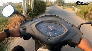 Scooty driving in small road.