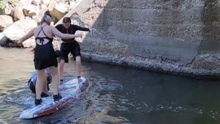 Three siblings struggle to balance on the surfboard at Susan River || WooGlobe